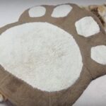 肉球クッションで寝る猫